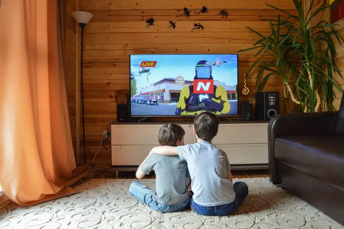 Persona che guarda la TV in un salotto accogliente con luci soffuse