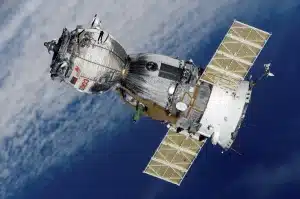 Una navicella spaziale solitaria nel sistema solare con pianeti e campi di asteroidi sullo sfondo.
