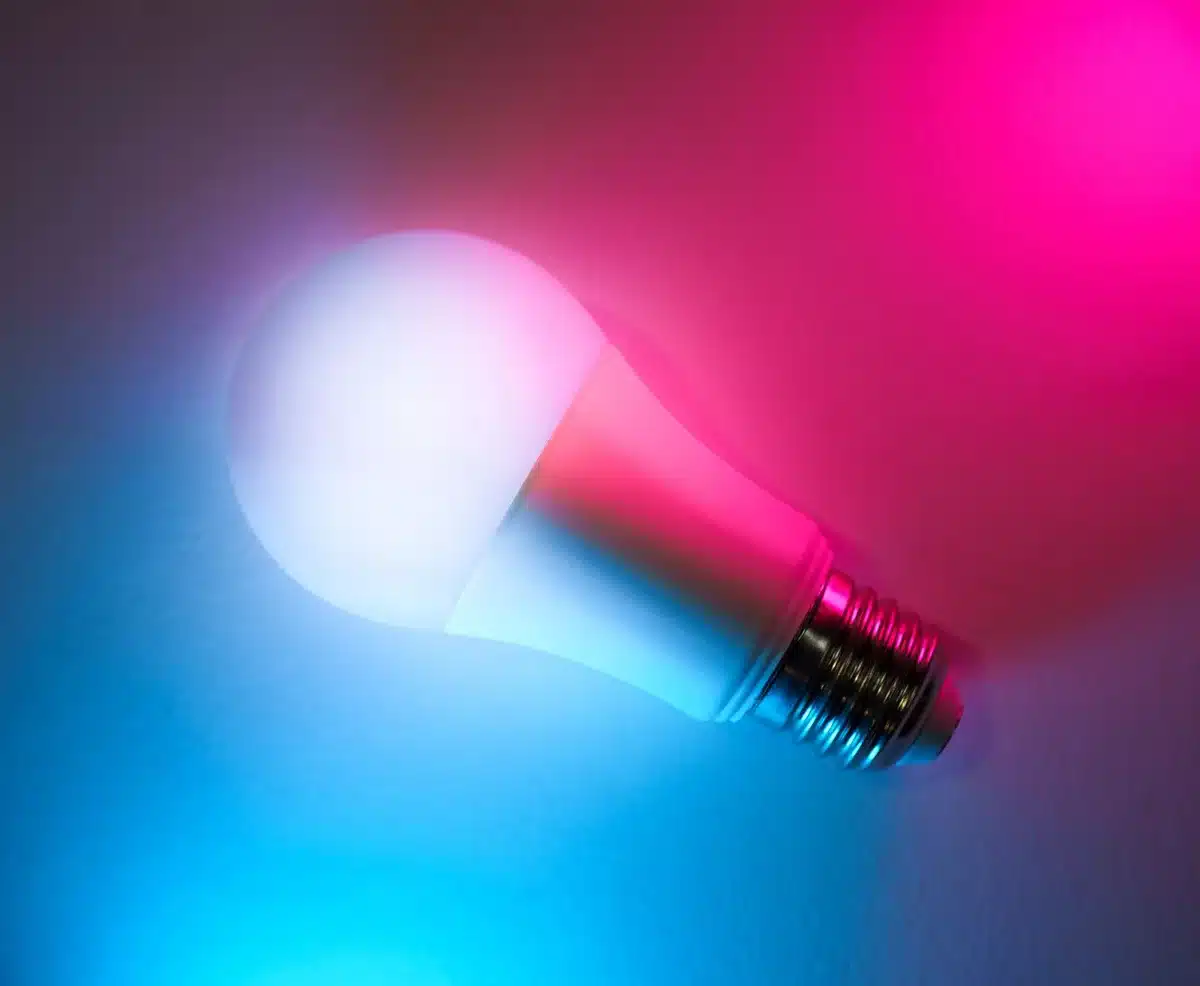 Figura con energia telepatica luminosa attorno alle mani in un ambiente moderno scuro