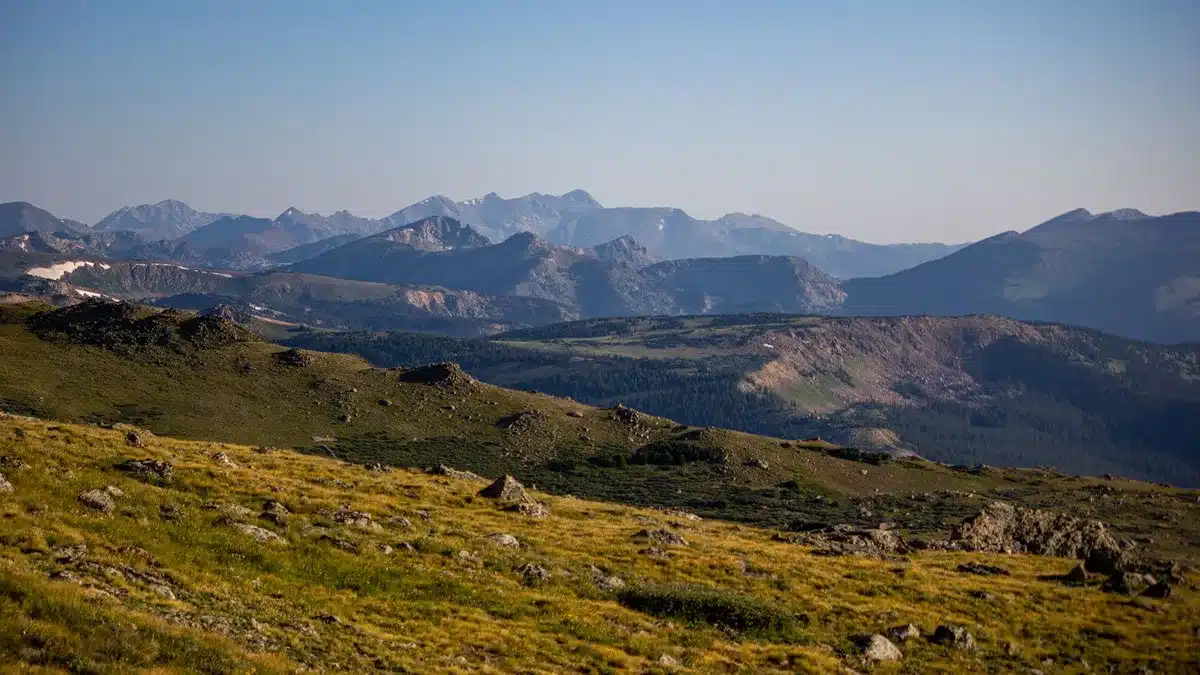 Paesaggio montano desolato con vette rocciose e valli nebbiose, atmosfera post-apocalittica