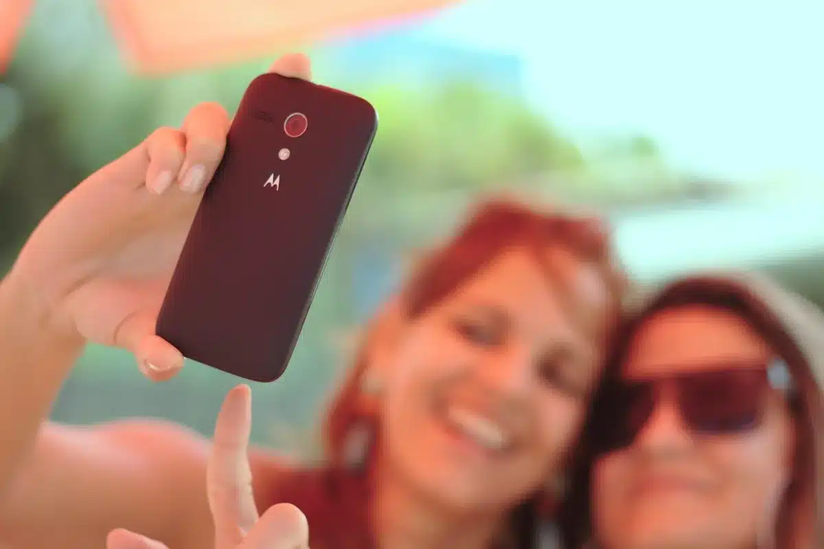 Persone che scorrendo contenuti sui telefonini mentre assistono a immagini di cronaca