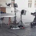 Set cinematografico di grandi dimensioni con numerosi membri della troupe e comparse al lavoro