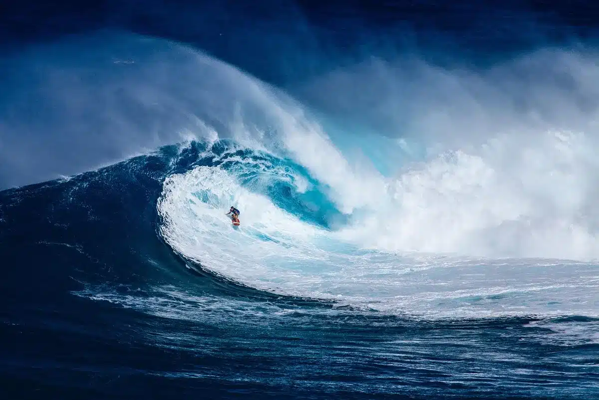 Surfer con tavola in mano vicino a bagnasciuga, atmosfera drammatica