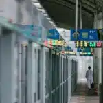 Piattaforma della metropolitana con figure anonime e atmosfera di tensione