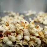 Mani anonime con popcorn e biglietto in una sala cinema affollata