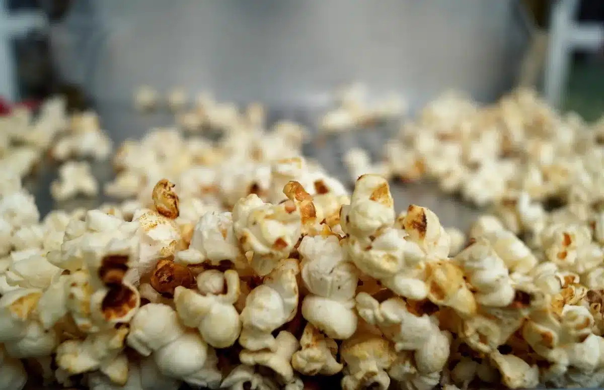 Mani anonime con popcorn e biglietto in una sala cinema affollata