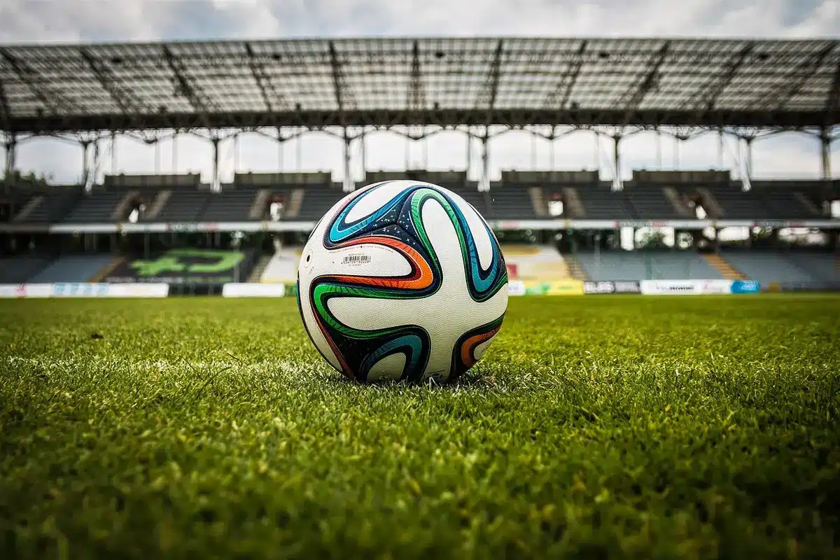 Donna in controluce seduta su una panchina vicino a uno stadio
