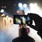 Pubblico silhouette in auditorium del festival davanti a un palco con microfono