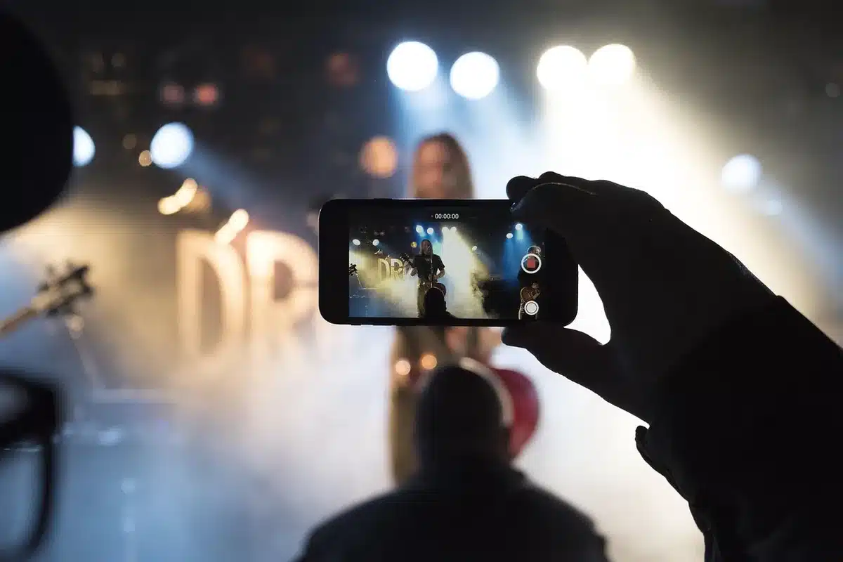 Pubblico silhouette in auditorium del festival davanti a un palco con microfono