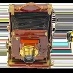 Silhouette di una cinepresa vintage su treppiede con macchina da scrivere e sceneggiature in uno studio