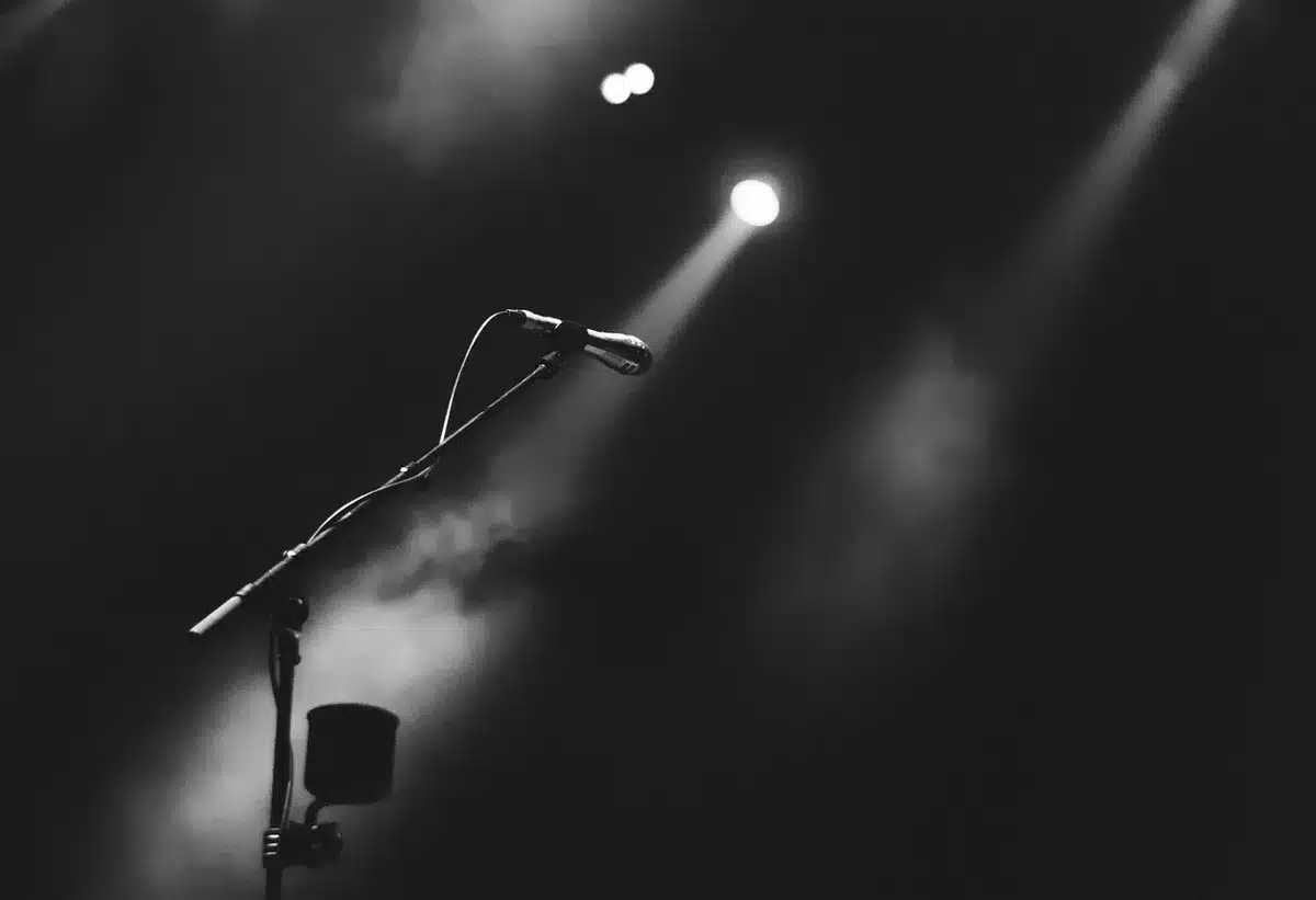 Attori in prova su un piccolo palco con costumi e oggetti di scena