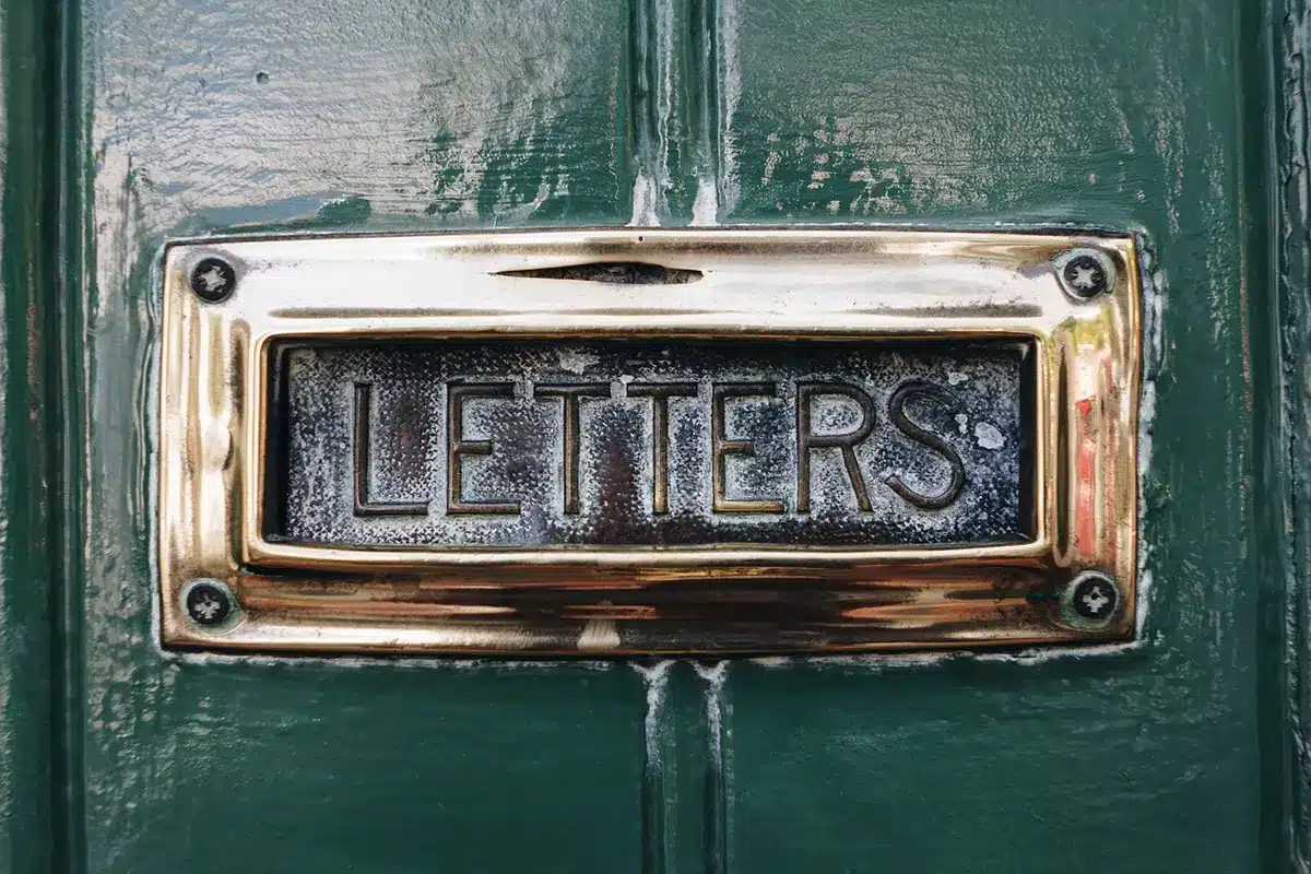 Casa suburbana con casella postale e lettere sul vialetto
