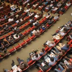 Spettatori in silhouette in una sala cinematografica indipendente, atmosfera di applauso