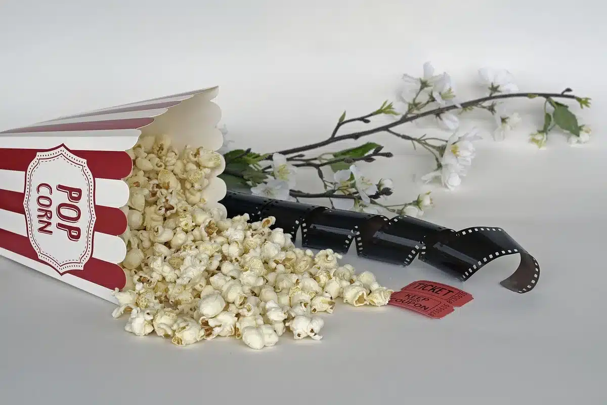 Folla anonima davanti a un cinema d'epoca con luci al neon e biglietti in mano