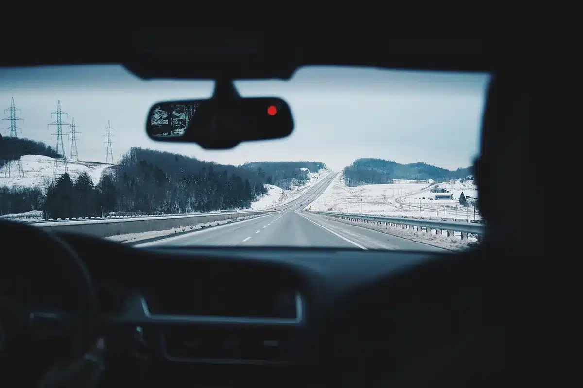 Auto d'epoca in una strada deserta che evoca un viaggio di liberazione